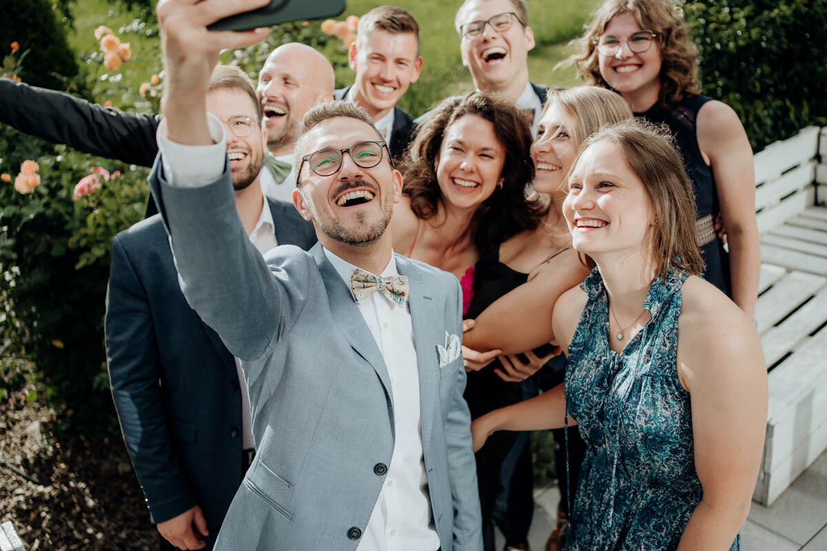 Gäste beim Gruppenselfie auf der Hochzeit