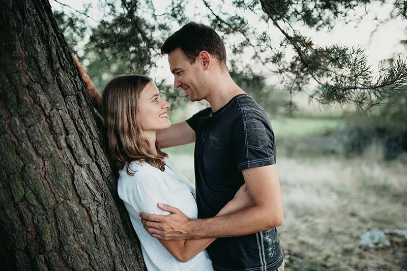 Paar an einem Baum beim Kennenlernshooting, helles Hemd und dunkles Shirt